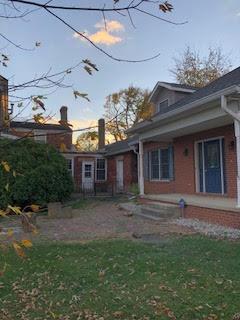 back house at dusk featuring a yard