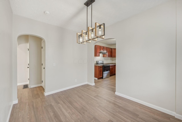 empty room featuring a textured ceiling and light wood-type flooring