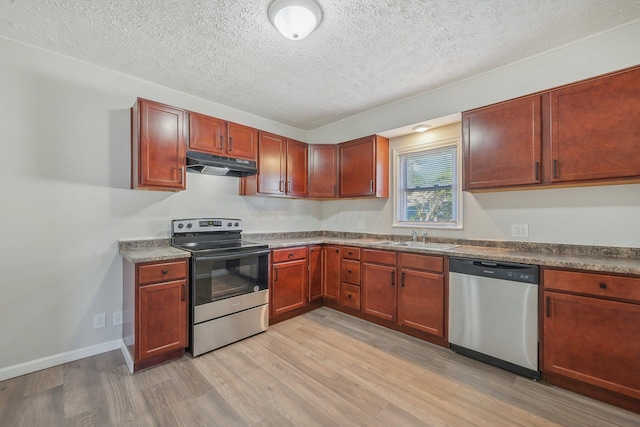 kitchen featuring sink, stainless steel appliances, a textured ceiling, and light hardwood / wood-style floors