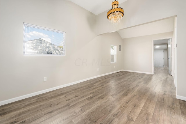 interior space with plenty of natural light, wood-type flooring, and an inviting chandelier