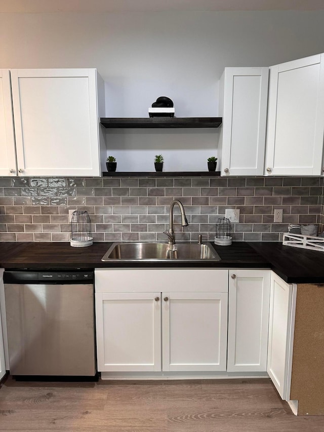 kitchen with white cabinetry, dishwasher, light hardwood / wood-style floors, and sink