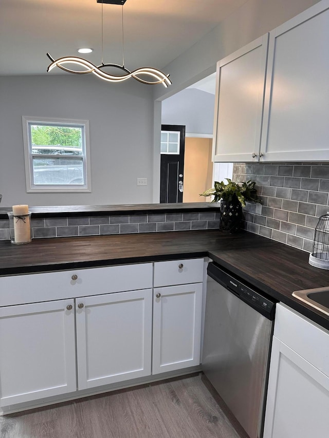 kitchen with dishwasher, white cabinets, pendant lighting, and wood counters