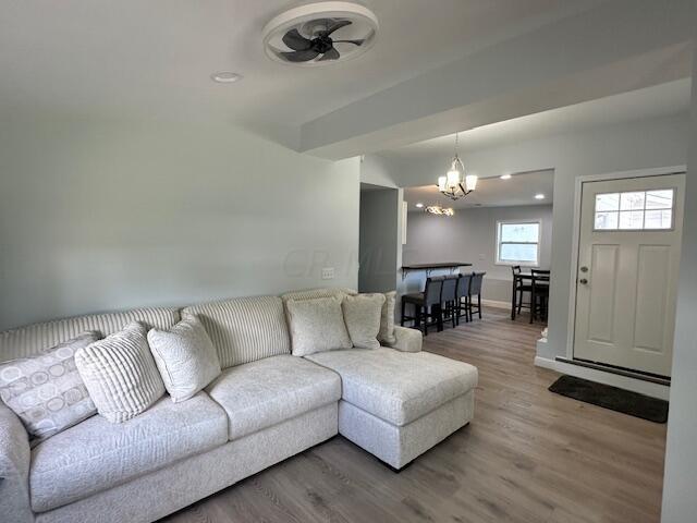 living room featuring hardwood / wood-style floors and ceiling fan with notable chandelier