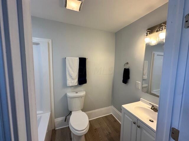 bathroom with vanity, hardwood / wood-style flooring, and toilet