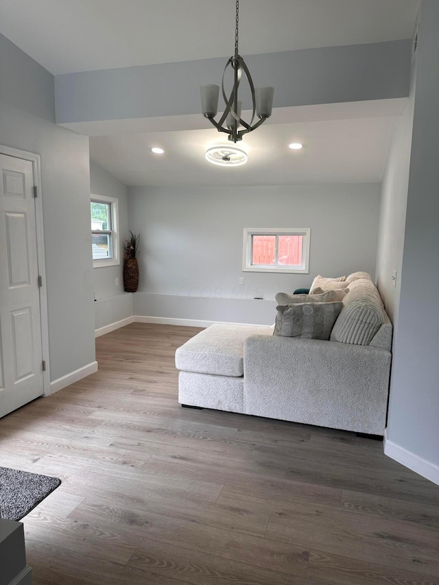 living room with hardwood / wood-style floors, a chandelier, and lofted ceiling