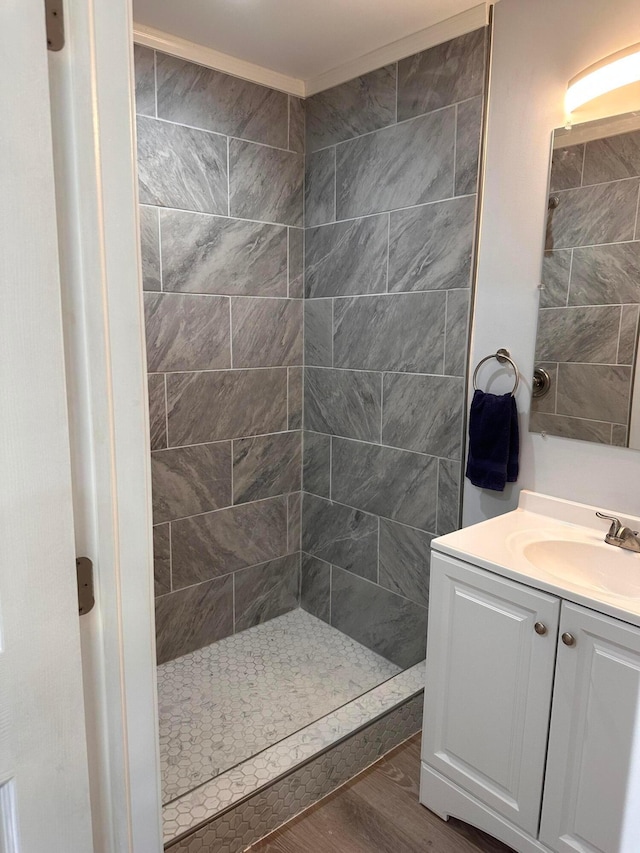 bathroom featuring tiled shower, vanity, and hardwood / wood-style flooring