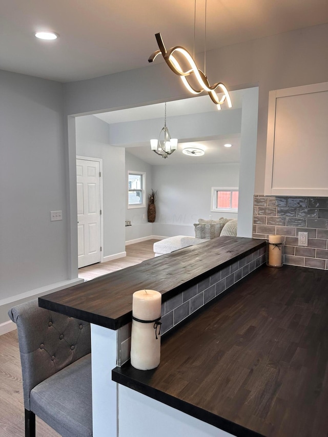 kitchen with pendant lighting, dark hardwood / wood-style flooring, white cabinets, and butcher block counters