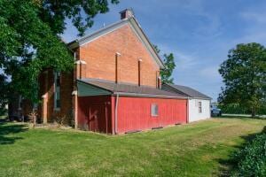 rear view of house featuring a yard