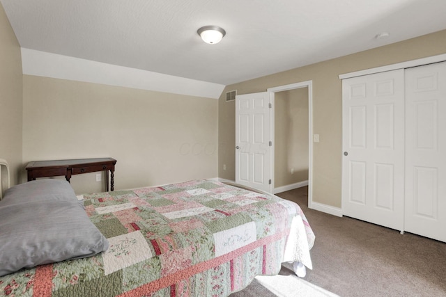 carpeted bedroom with a closet and vaulted ceiling