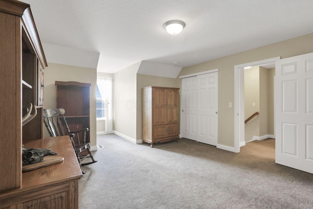 carpeted office with vaulted ceiling