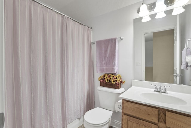 bathroom featuring toilet, vanity, and a shower with curtain