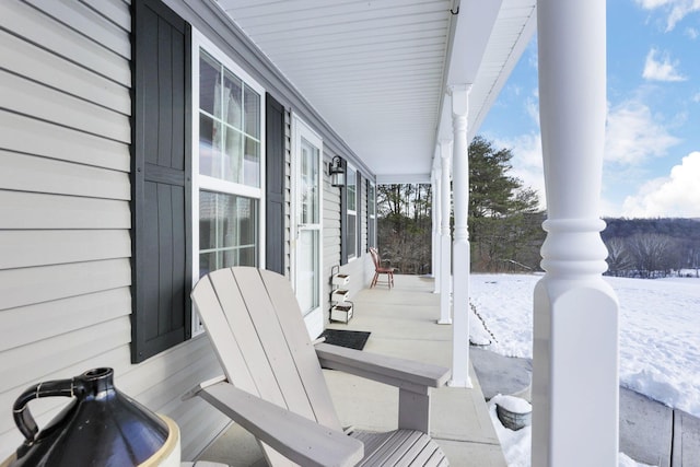 snow covered patio featuring covered porch