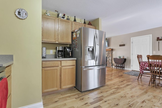 kitchen with stainless steel fridge, light wood-type flooring, and light brown cabinetry