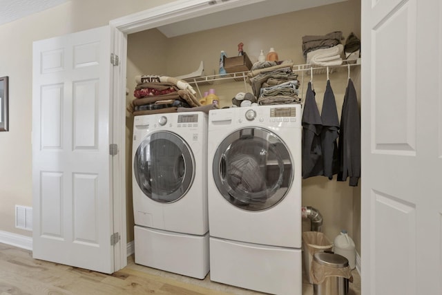 laundry room featuring light hardwood / wood-style flooring and washer and clothes dryer