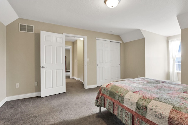 bedroom with dark carpet, a closet, and vaulted ceiling