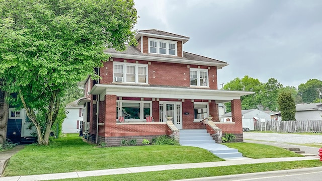 view of front of property featuring covered porch and a front yard