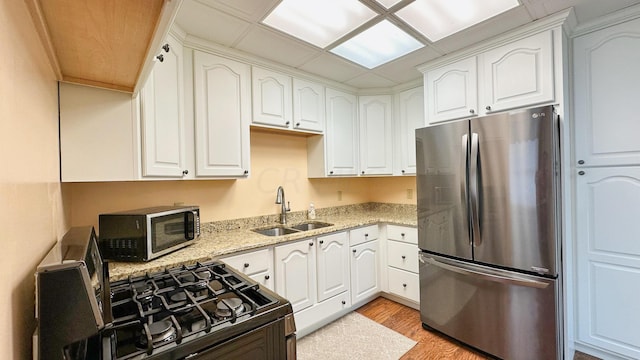 kitchen with sink, white cabinetry, and stainless steel appliances