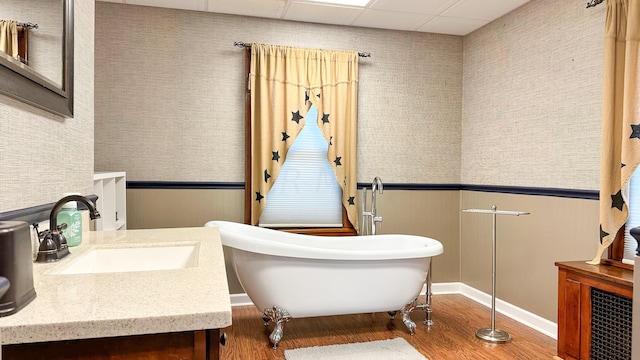 bathroom with vanity, wood-type flooring, a paneled ceiling, and a bathing tub