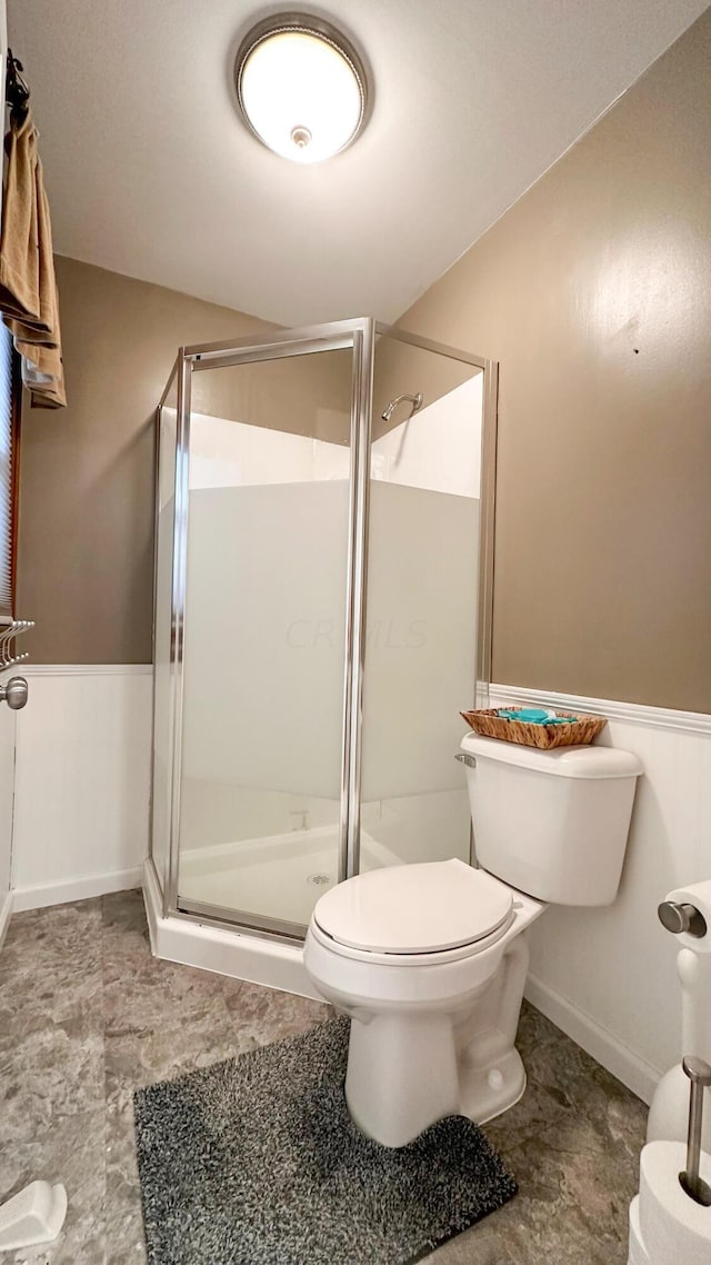 bathroom with toilet and a shower with door