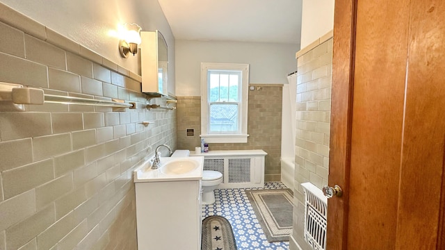 bathroom featuring vanity, tile walls, and toilet