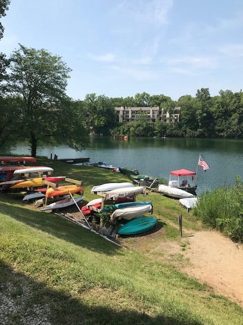 surrounding community featuring a yard, a dock, and a water view