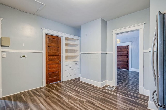 interior space featuring stainless steel refrigerator and dark hardwood / wood-style flooring