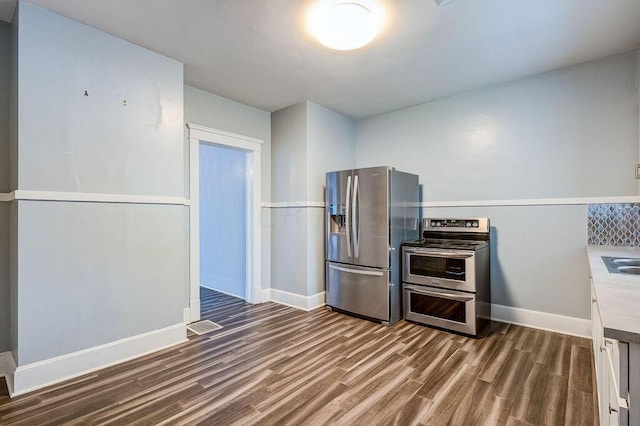 kitchen with stainless steel appliances and dark wood-type flooring