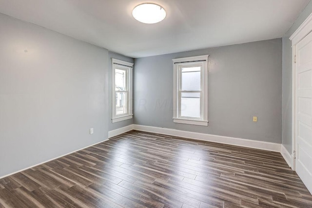 unfurnished room with dark hardwood / wood-style flooring