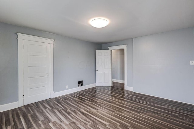 spare room featuring dark wood-type flooring