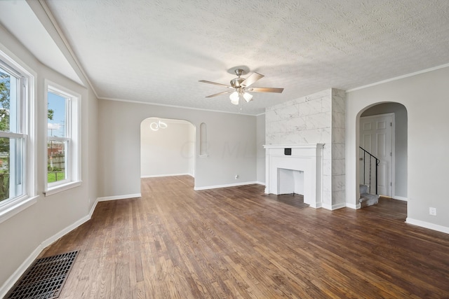 unfurnished living room with a textured ceiling, a wealth of natural light, a fireplace, and dark hardwood / wood-style floors