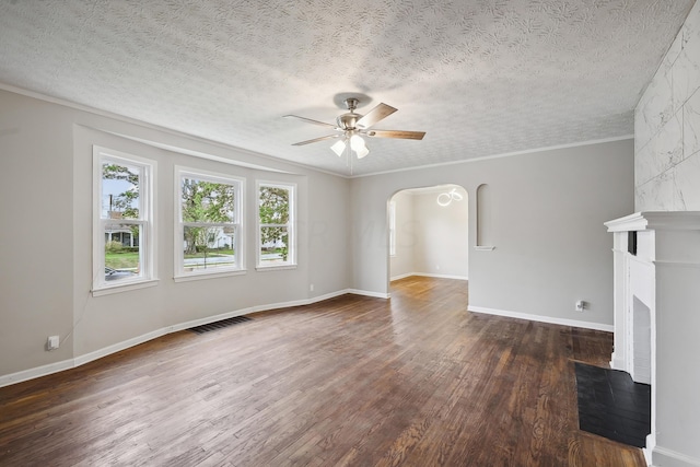 unfurnished living room with a textured ceiling, ceiling fan, a large fireplace, and dark hardwood / wood-style floors