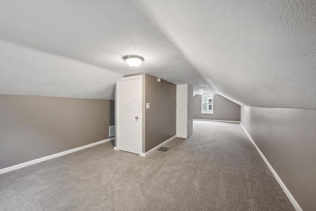 bonus room featuring carpet flooring, a textured ceiling, and vaulted ceiling