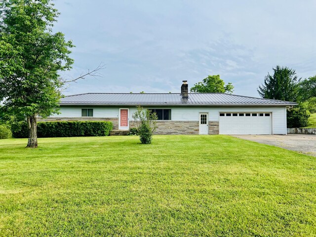 single story home with a garage and a front lawn