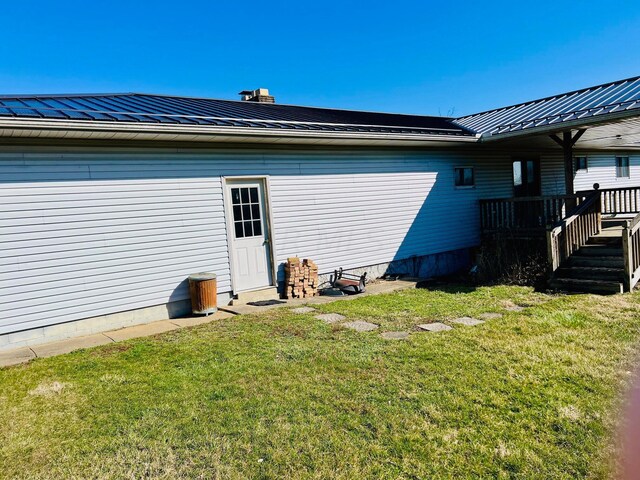 rear view of house with a wooden deck and a yard