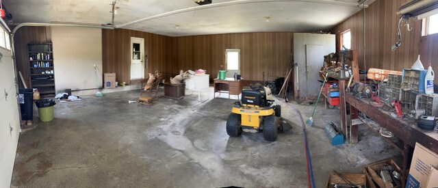 garage featuring a workshop area and wooden walls