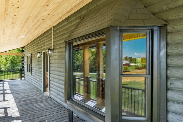 exterior space with hardwood / wood-style floors, rustic walls, and a wealth of natural light