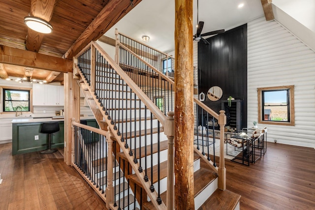 stairway featuring hardwood / wood-style floors, sink, ceiling fan, beam ceiling, and wood ceiling