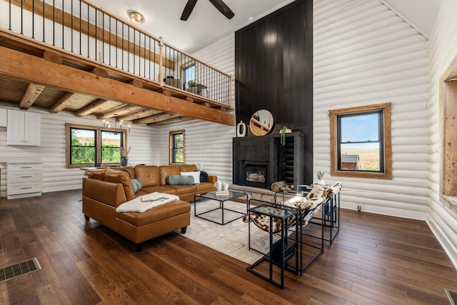 living room featuring ceiling fan, wood-type flooring, and a high ceiling