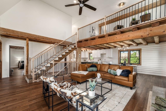 living room with hardwood / wood-style floors, ceiling fan, and high vaulted ceiling