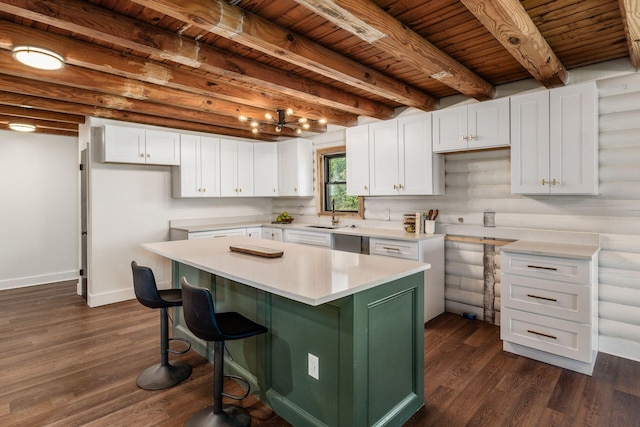 kitchen with white cabinetry, a center island, beamed ceiling, and dark hardwood / wood-style floors