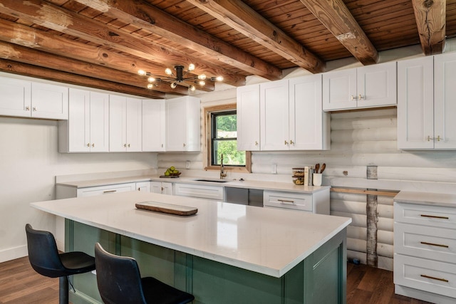 kitchen with a center island, sink, white cabinetry, and dark wood-type flooring