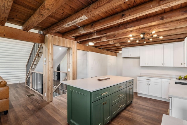 kitchen featuring beamed ceiling, a center island, green cabinets, and white cabinetry