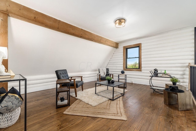 living area with log walls, lofted ceiling with beams, and dark hardwood / wood-style floors