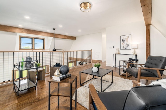 living room with hardwood / wood-style flooring, ceiling fan, and beamed ceiling