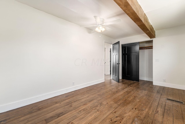 unfurnished bedroom featuring ceiling fan, a closet, beamed ceiling, and dark hardwood / wood-style floors