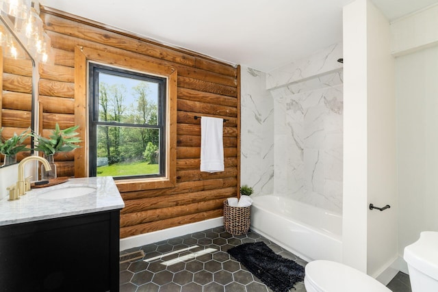 bathroom with tile patterned floors, vanity, log walls, and toilet