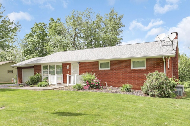 single story home with cooling unit, a front lawn, and a garage