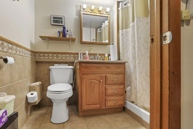 bathroom with vanity, tile walls, tile patterned flooring, toilet, and curtained shower