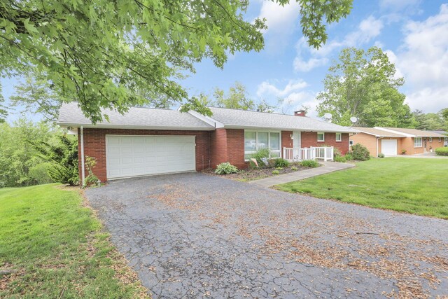 ranch-style home featuring a front lawn and a garage