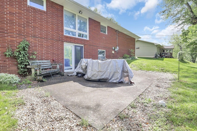 back of property featuring a lawn and a patio